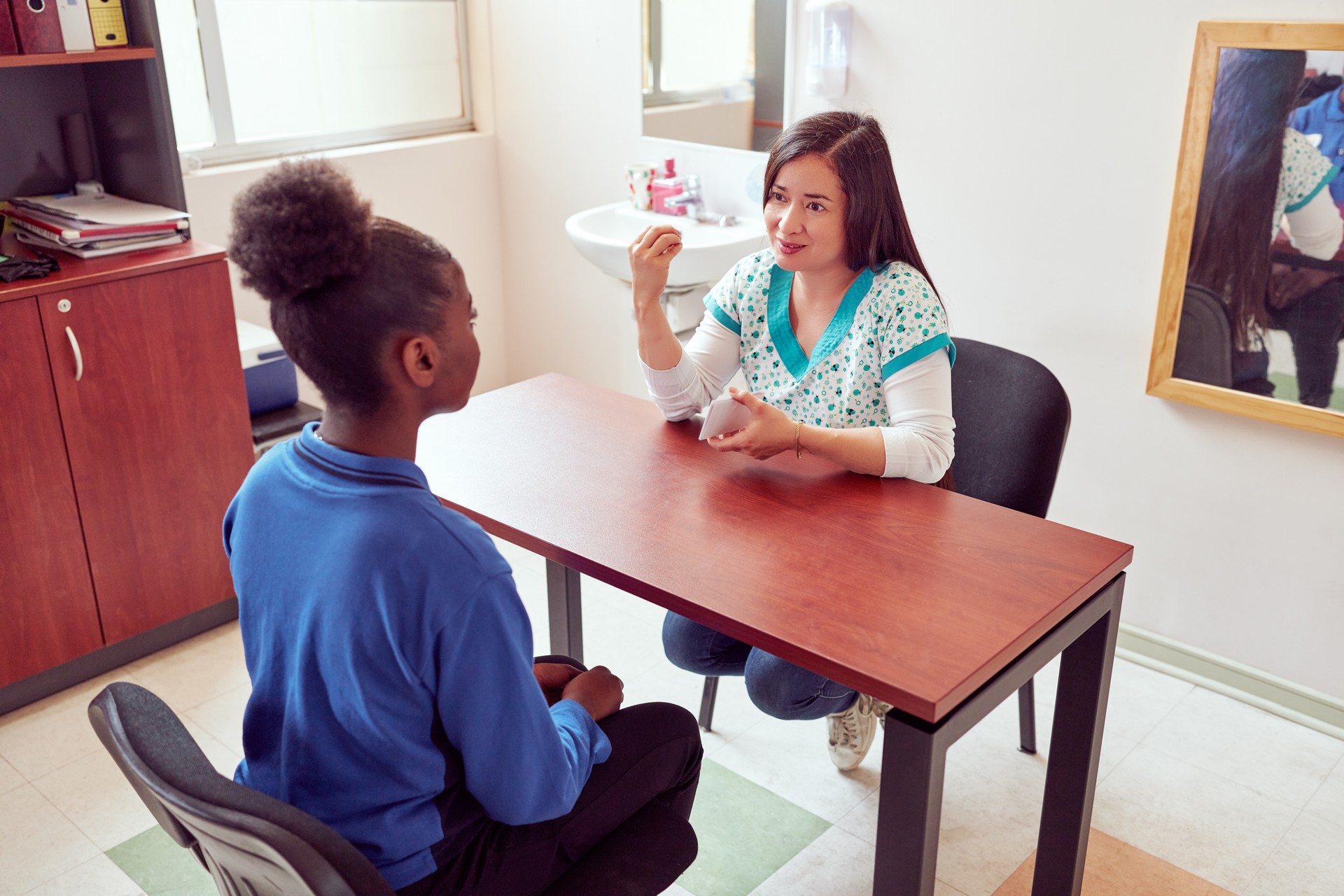 speech therapist working with teenage secondary school student